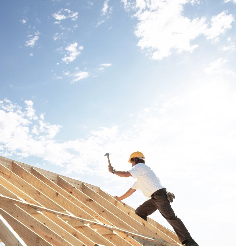 man building roof in new construction